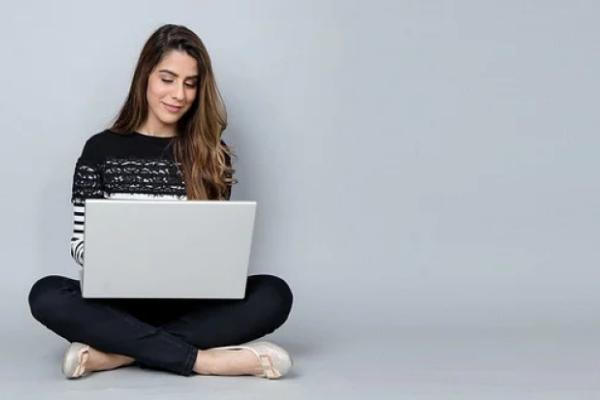 Mujer sentada con computadora para comprar acciones en Chile.