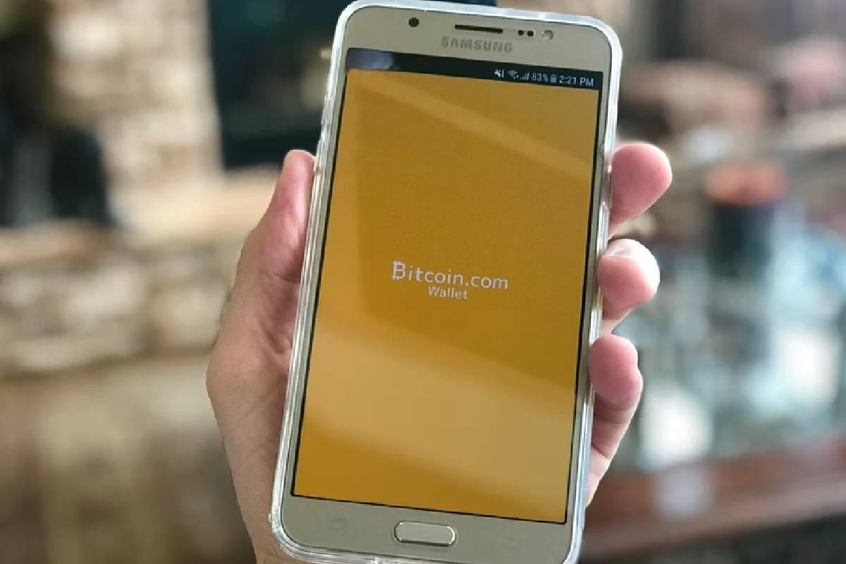 Una persona sostiene su celular mientras ingresa a bicotin.com, billetera virtual.