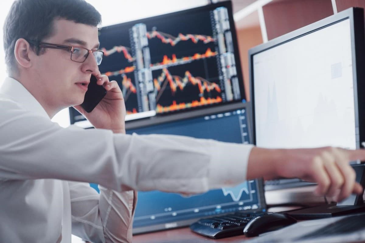 Corredor de bolsa conversa por teléfono sobre la bursatilidad de un activo.