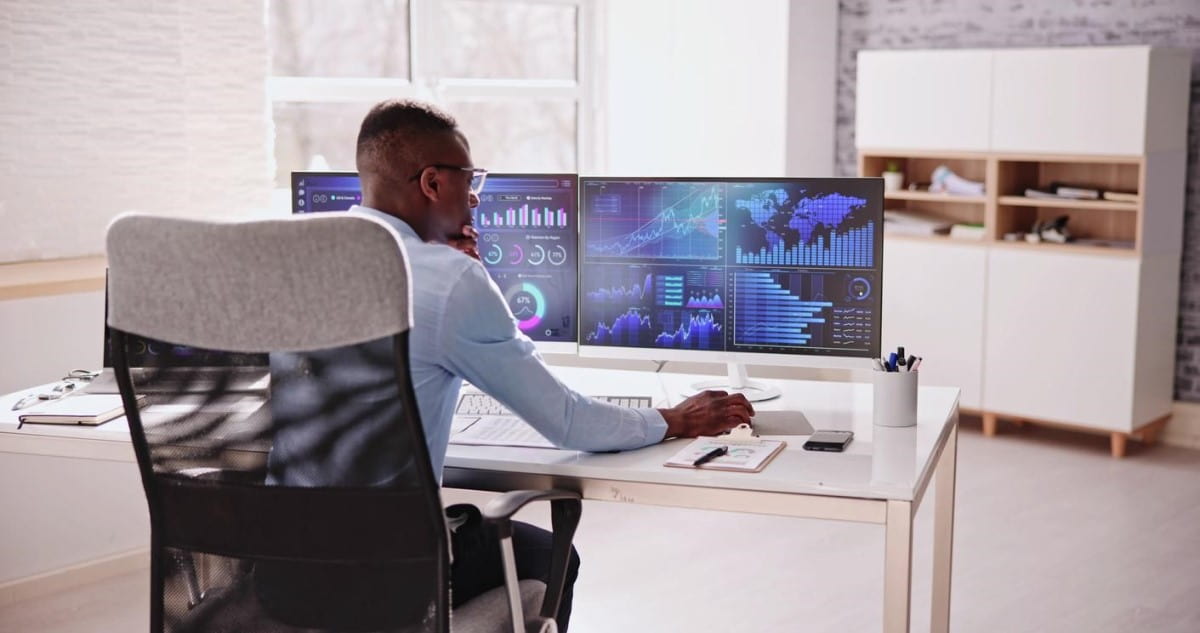 Un corredor de bolsa analiza estadísticas en su computador.