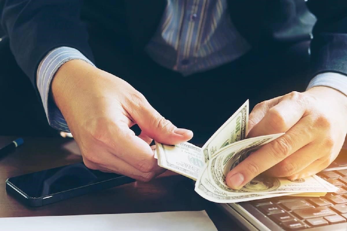 Un hombre cuenta dólares después de realizar intercambio de divisas.