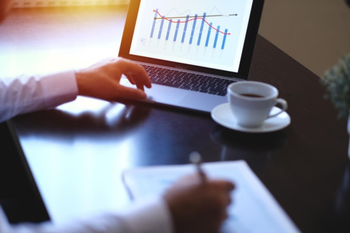 Empresario revisa gráficos en su tablet y analiza si le conviene invertir en dólar cripto.