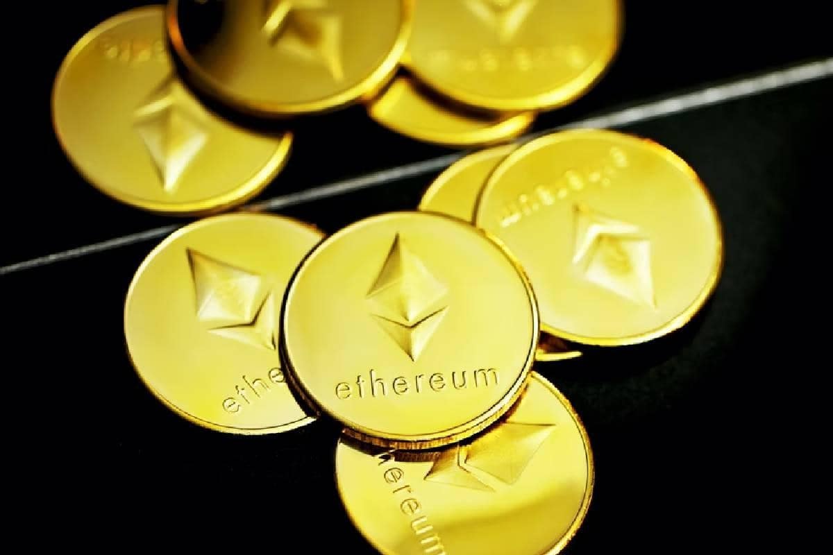 Monedas doradas grabadas con la palabra “Ethereum” y el logotipo, sobre fondo negro.
