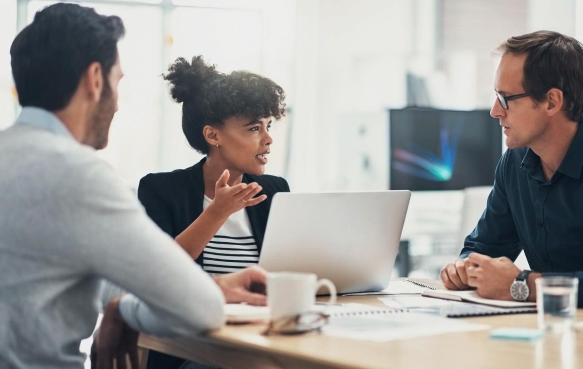 Colegas de oficina conversan sobre la rentabilidad de los fondos indexados.