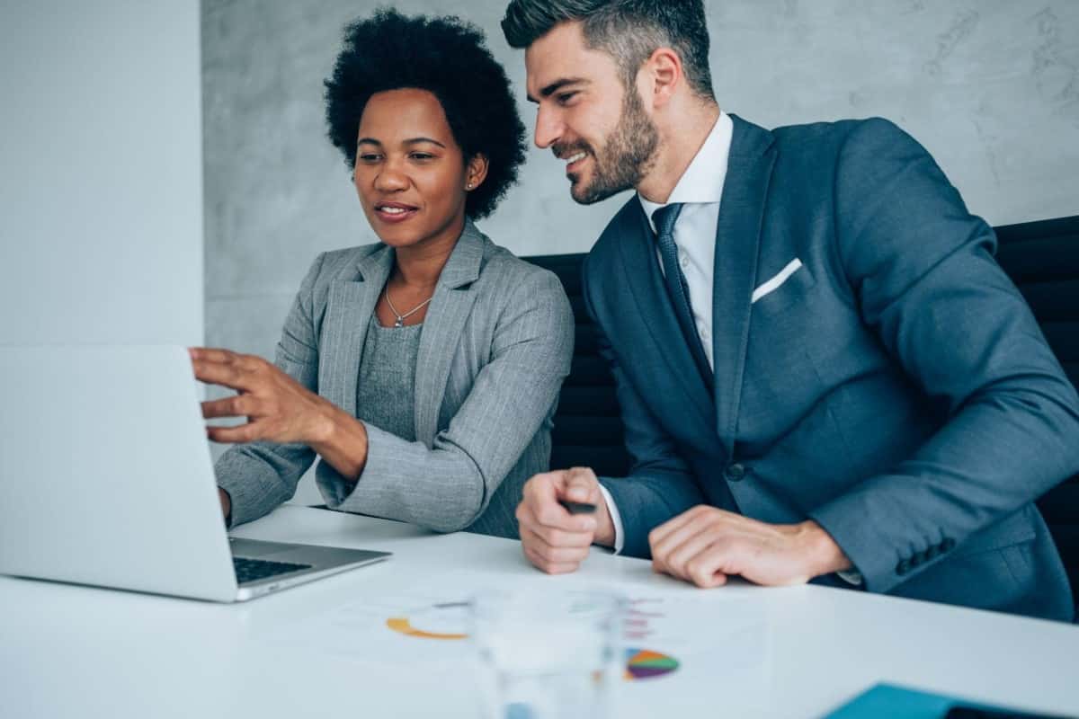 Ejecutivos analizan en una laptop las estadísticas del índice IGPA