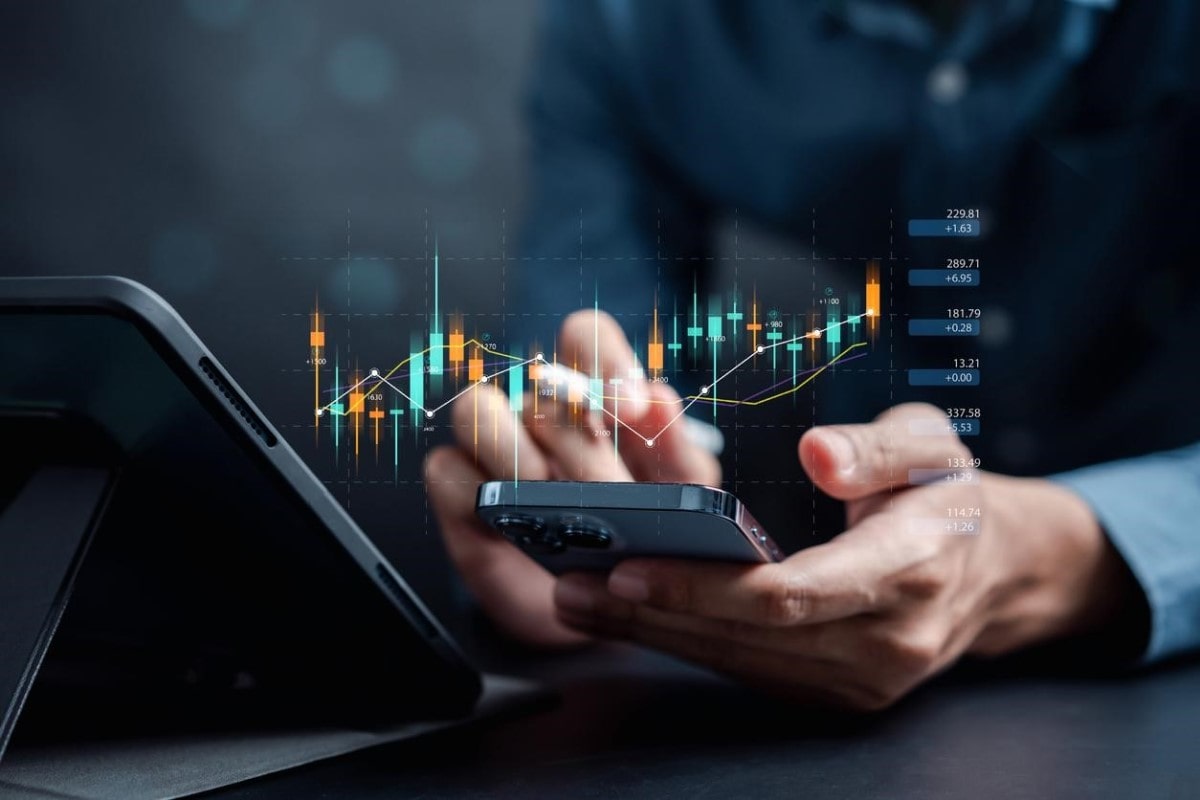 Inversionista analiza en su celular indicadores de trading.