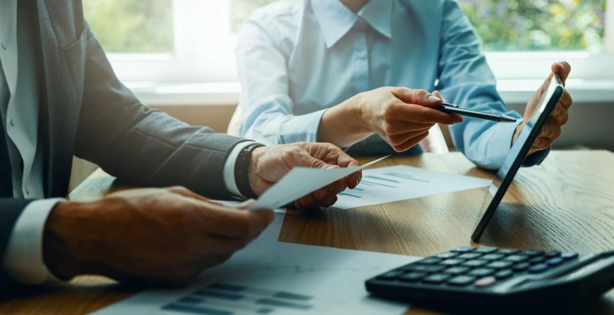 Dos personas revisan en una tablet resultados de una inversión pasiva.