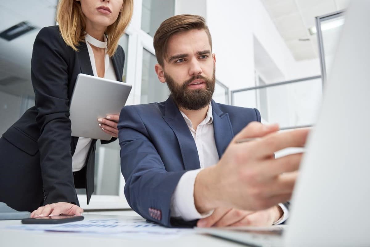 Empresario analiza con su asistente el riesgo de liquidez de su compañía.