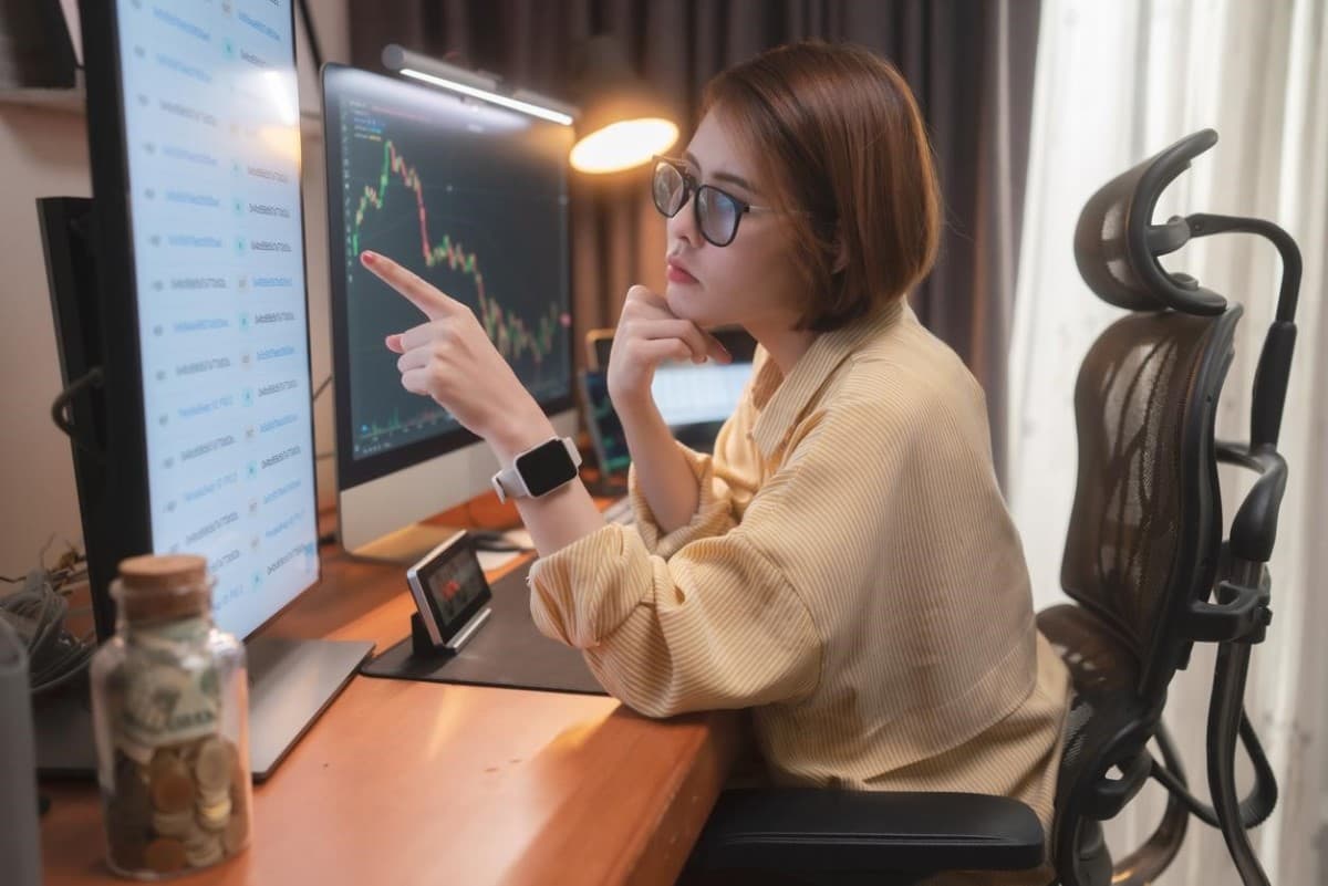Una joven trader revisa tendencia para elegir entre las mejores opciones para invertir.