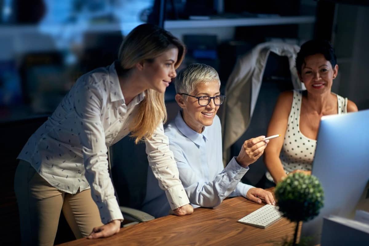 Mujeres de negocios buscan en una computadora tendencias de mercados emergentes para invertir.