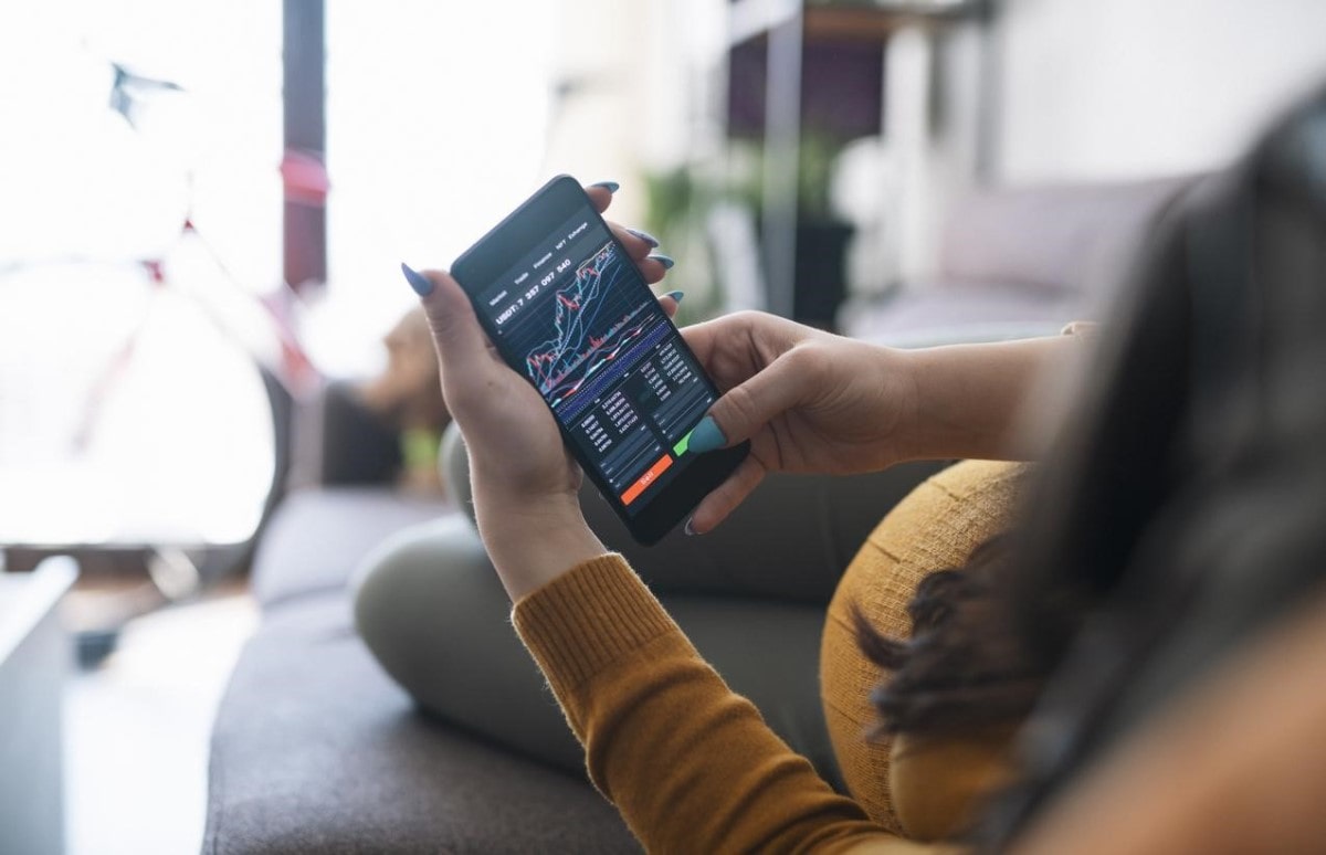 Una trader va a comprar una nueva criptomoneda desde su teléfono celular.