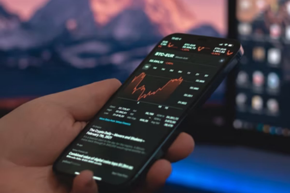 Persona mirando su celular averiguando qué es trading de opciones binarias.