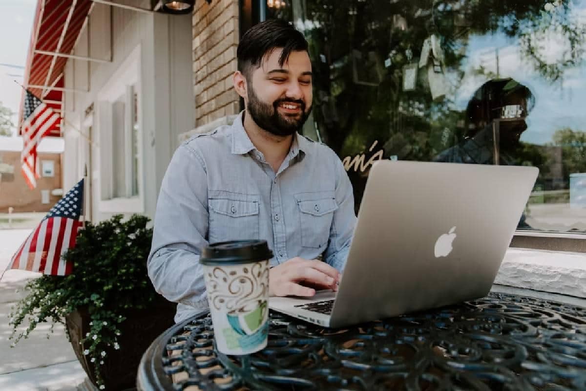 Hombre joven frente a una laptop averiguando el precio del oro en Chile.