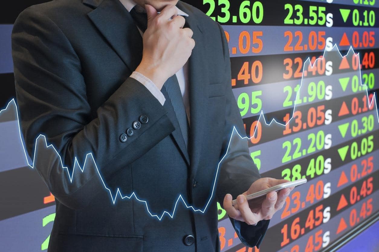 Foto conceptual de trading e inversiones. Un empresario analiza un punto crítico en sus operaciones desde el celular.