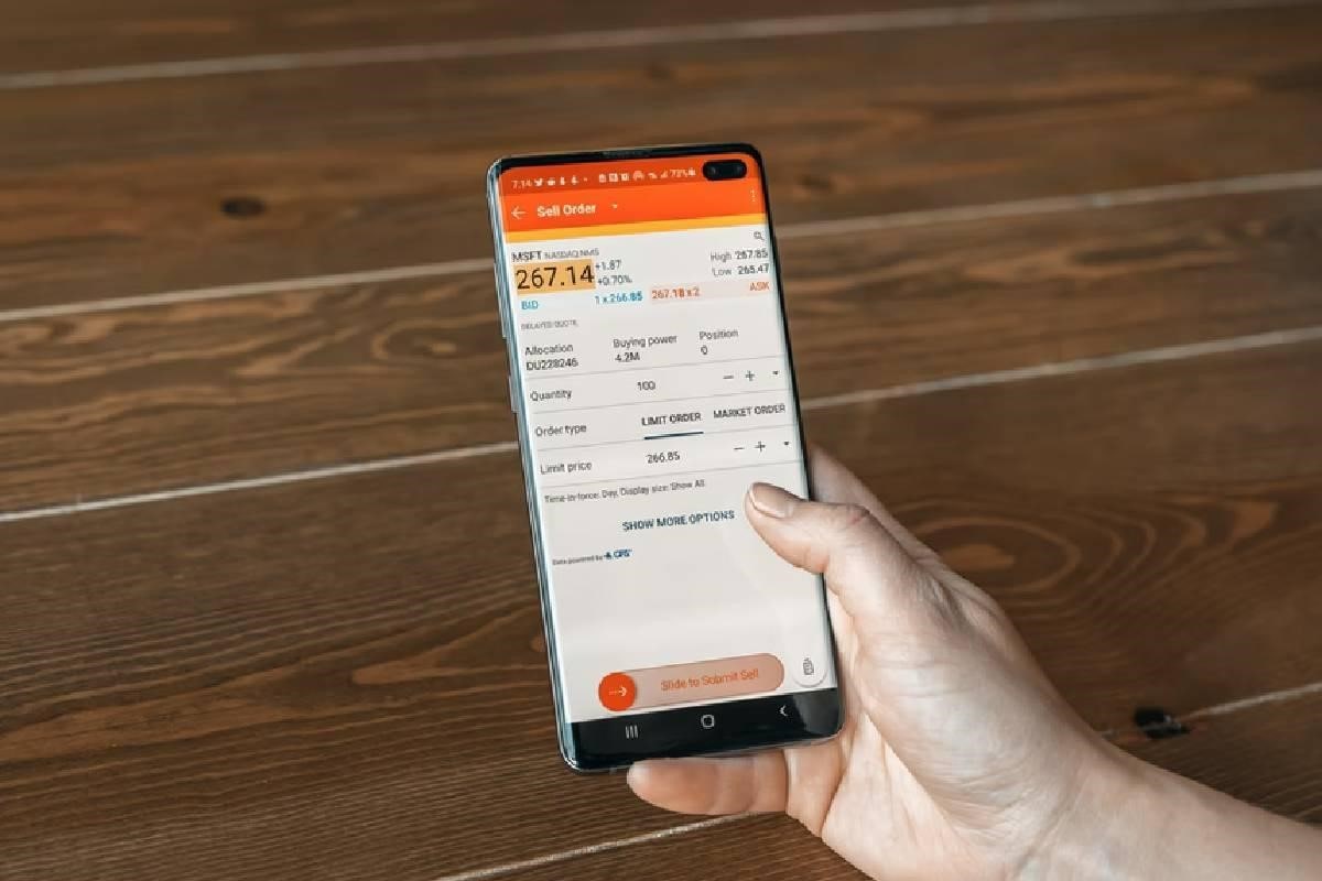 Una persona analiza desde su celular el precio de las acciones, uno de los activos que forman parte del riesgo beneficio