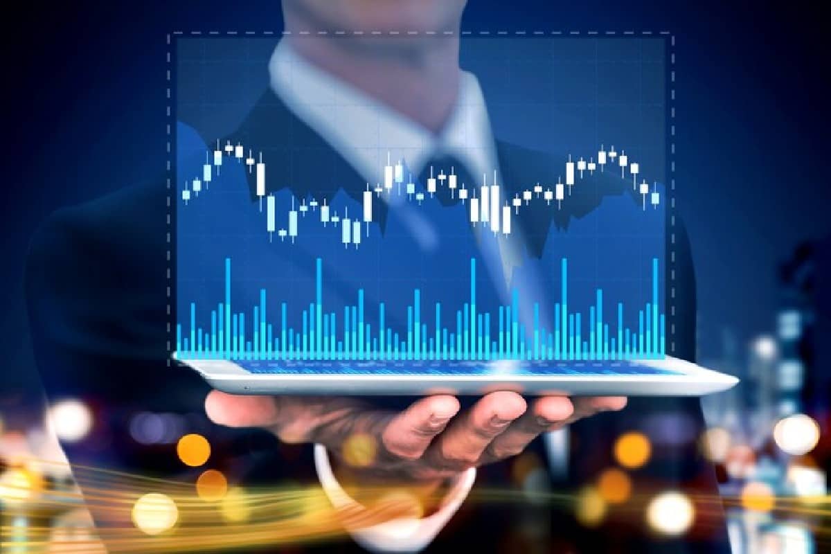 Persona sosteniendo una computadora con gráficos y RSI.