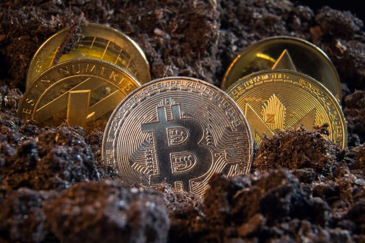 Una Bitcoin y otras criptos en tierra. Conoce los beneficios que brinda la aplicación del RSI en el mercado de criptomonedas.