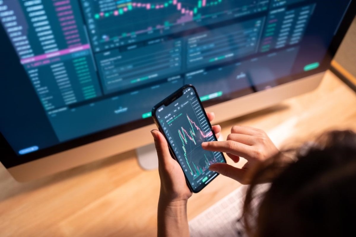 Una mujer revisa gráficos del precio del BTC porque analiza practicar scalping Bitcoin.