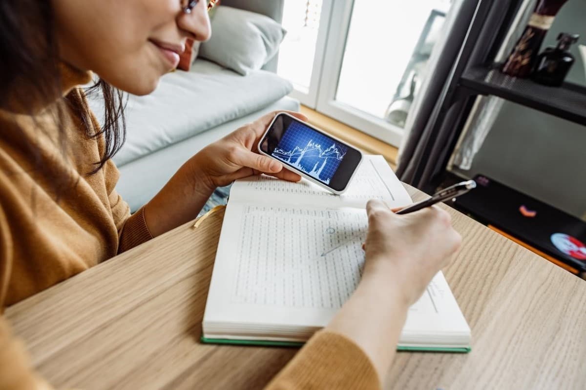 Una trader revisa en su celular gráficos de tendencia de Toncoin.