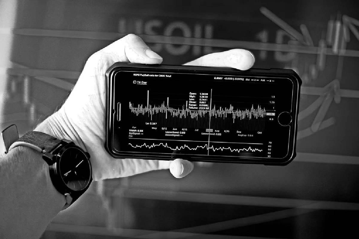 Un hombre analizando gráficos del mercado desde el celular