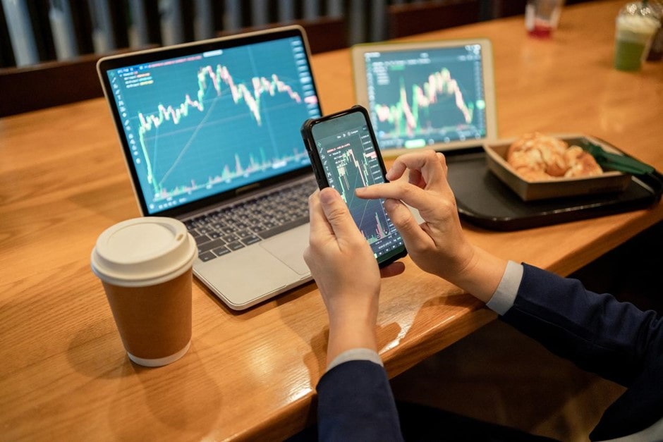 Un trader revisa en su computador y en su celular la XRP predicción.