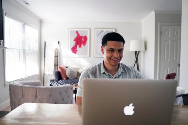 Chico frente a una laptop mientras realiza sus inversiones en Enel Chile