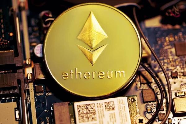 Moneda grabada con la palabra “Ethereum” y el logotipo, sobre una placa de computadora.