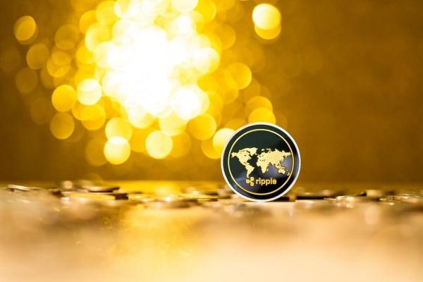 Una criptomoneda Ripple en un fondo dorado. Conoce la XRP predicción del 2023.