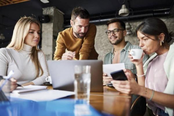 Equipo creativo de startups trabajando en una computadora.