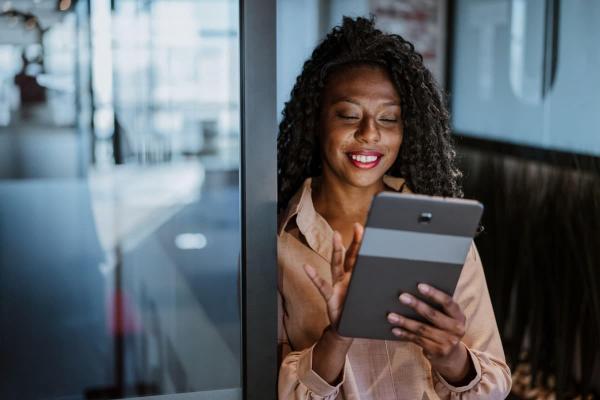Mujer de negocios investiga en su tablet cómo invertir en Index Chile.