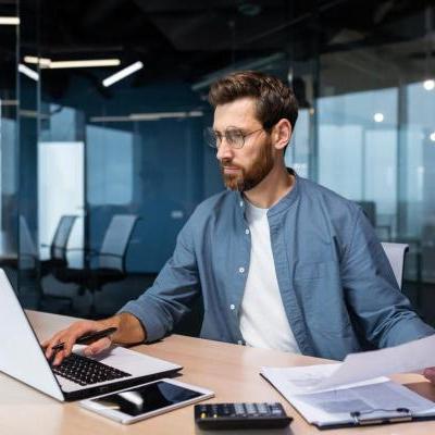 Un hombre estudia en su computador algunos derivados financieros.
