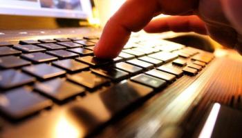 Persona presionando teclas en una computadora para investigar qué es el trading.