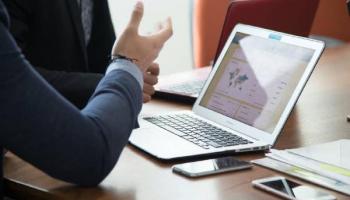 Hombre frente a la computadora analizando los sistemas de trading para Forex.