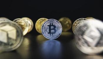 Bitcoin y otras crypto en un fondo oscuro. Descubre qué son las criptomonedas.