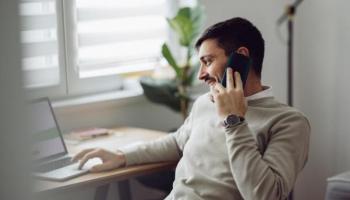 Joven conversa por celular sobre la posibilidad de invertir en un fondo de inversión indexado.