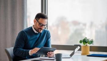 Empresario investiga en su tablet tendencias para invertir en materias primas.