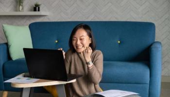 Una joven inversionista celebra frente a la computadora su libertad financiera