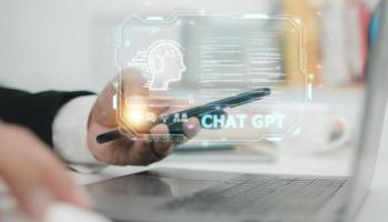 Hombre indaga en su computador y en su celular cómo funciona ChatGPT.