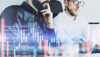 Un par de empresarios analizan un gráfico de velas.