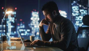 Un hombre de negocios investiga en su laptop sobre el mercado OTC.