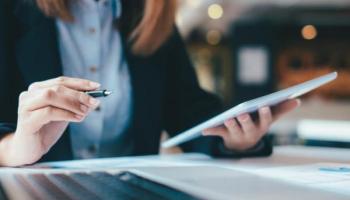 Una empresaria estudia datos financieros para un análisis de riesgo de su compañía.