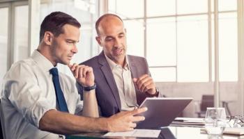 Dos inversores analizan un proyecto de crowdfunding inmobiliario.