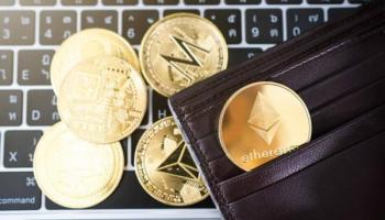 ETH y otras cripto sobre un teclado. Descubre cómo invertir en criptomonedas.