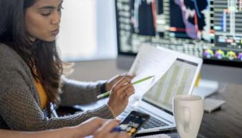 Dos jóvenes inversionistas analizan datos sobre las acciones baratas.