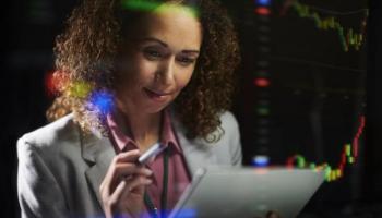 Empresaria analiza tendencias en su tablet porque aprendió cómo interpretar gráficas.