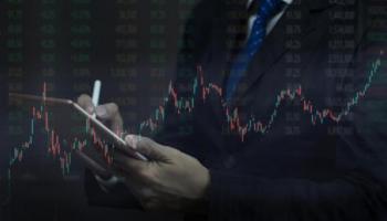 Un hombre revisa gráficas y números en su tablet para comprar acciones en Ecuador.