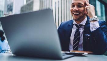 Un empresario investiga en su laptop qué es y cómo invertir en QQQ.